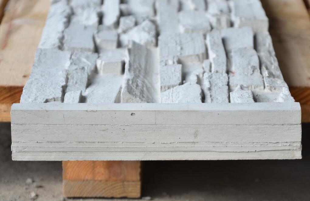 Boční strana betonové plotové desky DEKOR, která se zasouvá do betonových sloupků